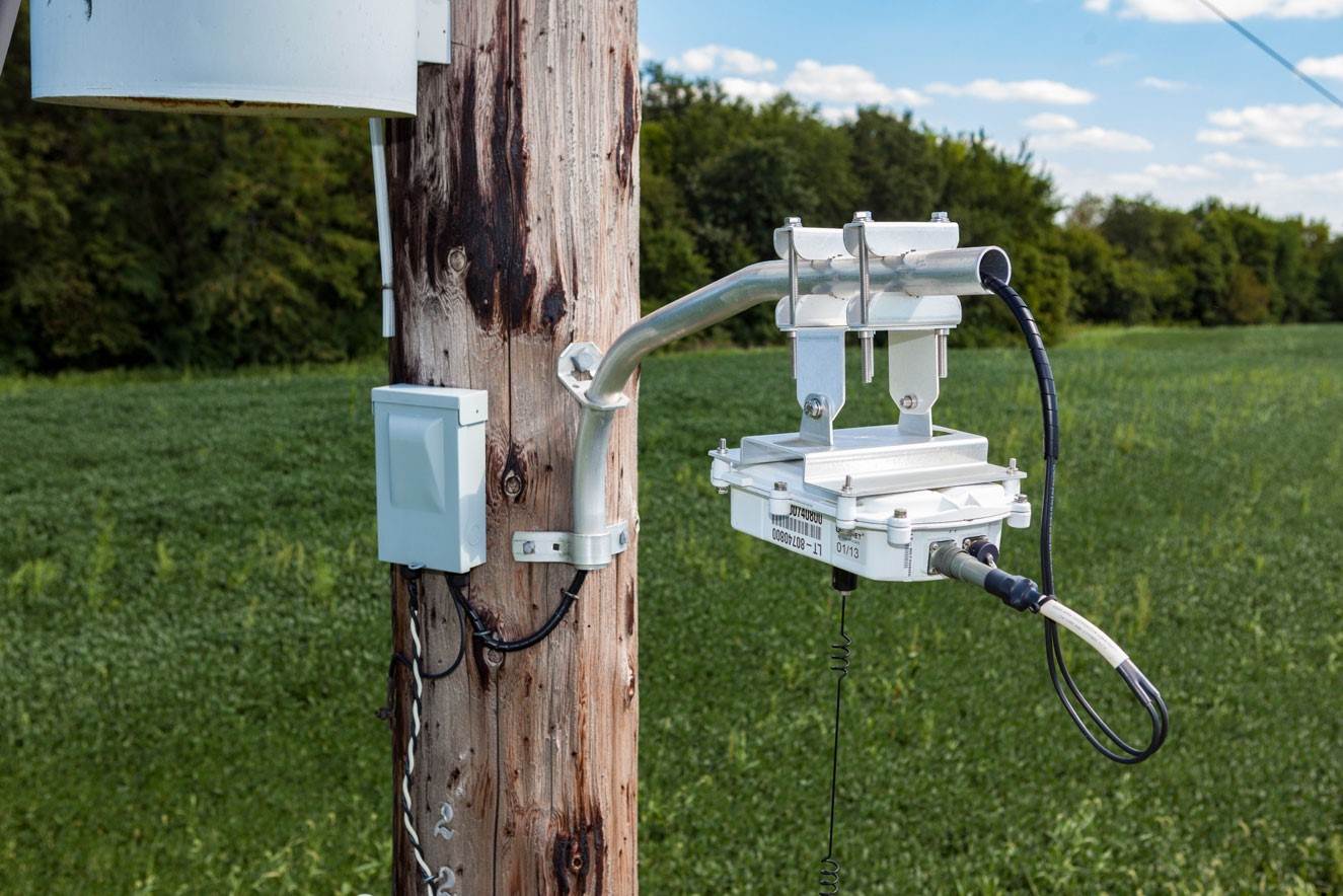 Close-up image of a wooden pole with a device attached