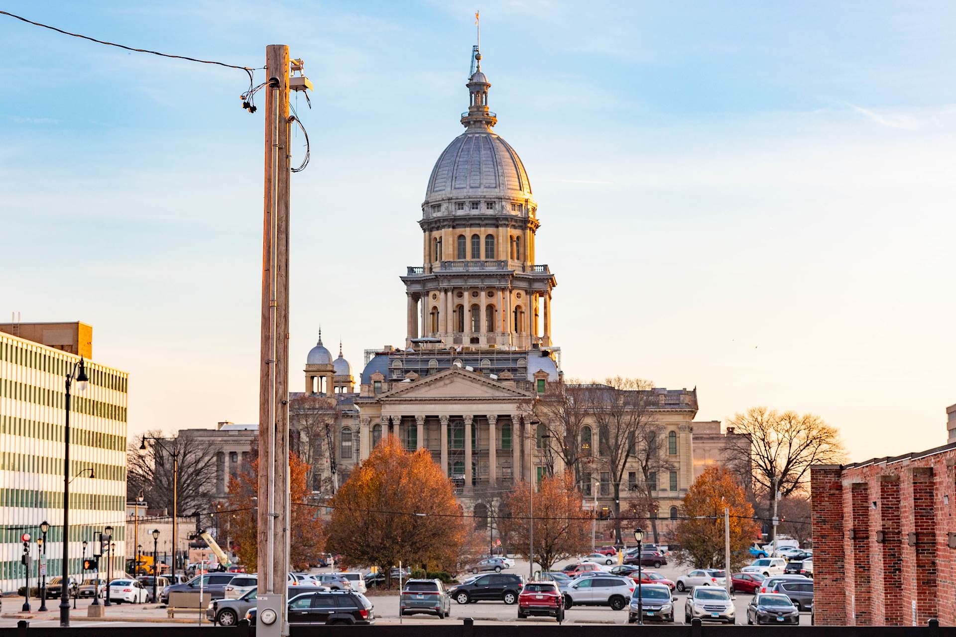 Photo of a power pole in the foreground with a domed capitol building in the background